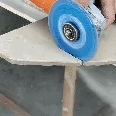 Angle grinder fitted with a blue DiscMate diamond cutting disc cutting through a stone slab