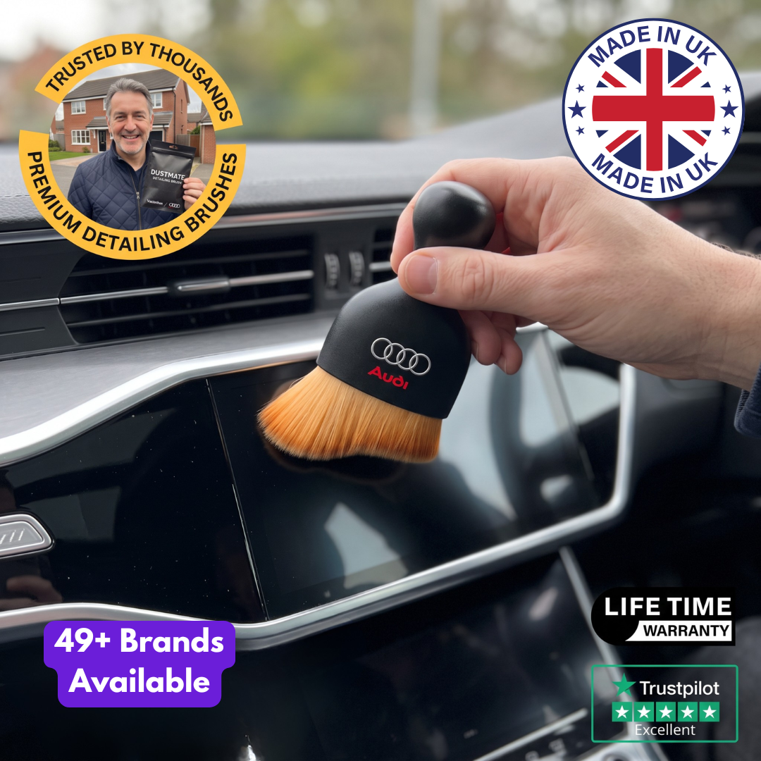 DustMate car detailing brush with the Audi logo engraved on the handle, dusting the edge of a car touchscreen