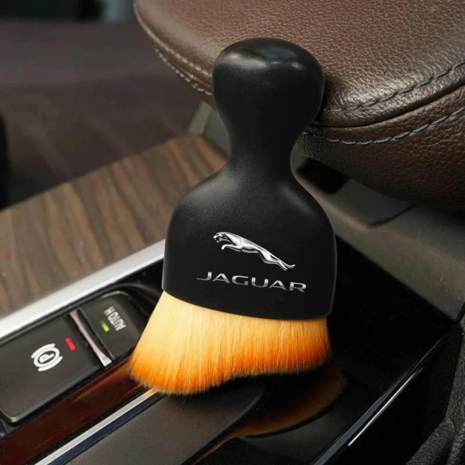 DustMate car detailing brush with the Jaguar logo engraved on the handle, next to a car seat