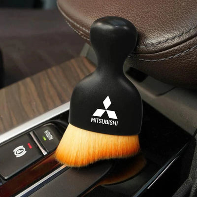 DustMate car detailing brush with the Mitsubishi logo engraved on the handle, next to a car seat