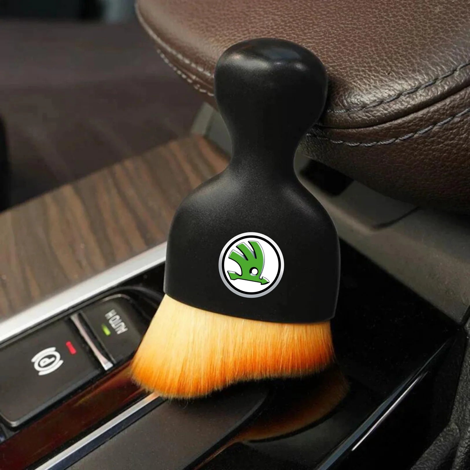 DustMate car detailing brush with the Skoda logo engraved on the handle, next to a car seat