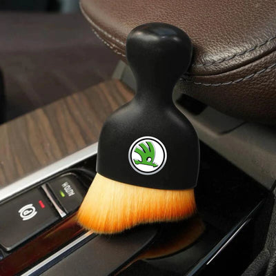 DustMate car detailing brush with the Skoda logo engraved on the handle, next to a car seat