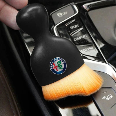 DustMate car detailing brush with the Alfa Romeo logo engraved on the handle, held over a car centre console