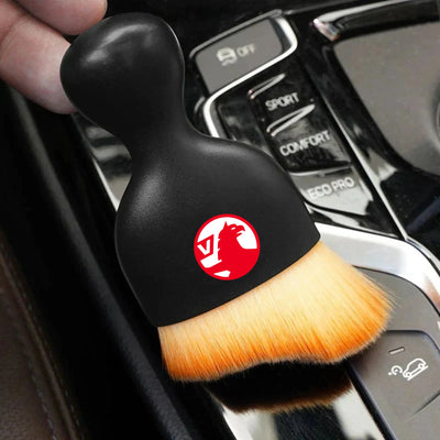 DustMate car detailing brush with the Vauxhall logo engraved on the handle, held over a car centre console