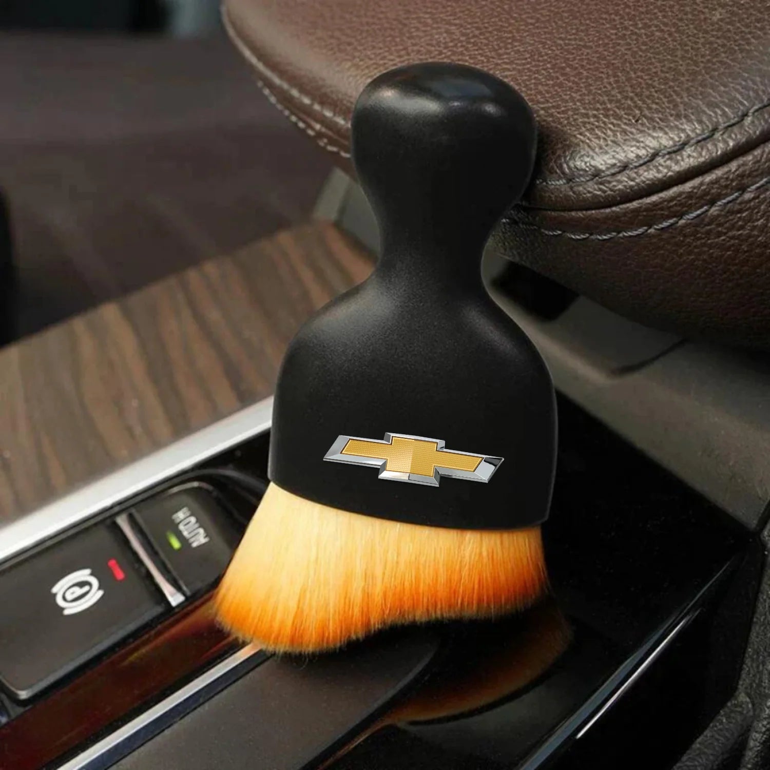 DustMate car detailing brush with the Chevrolet logo engraved on the handle, next to a car seat