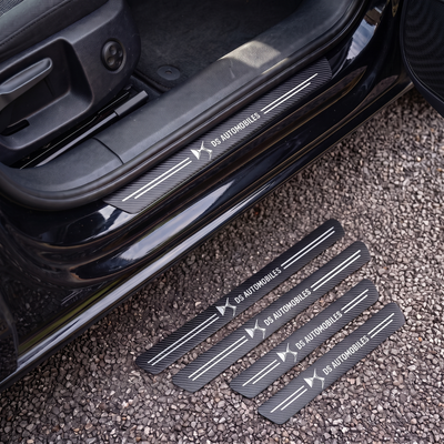 CarbonGrip PRO door sill protectors with DS logo: one fitted on the sill, set of 4 on the ground