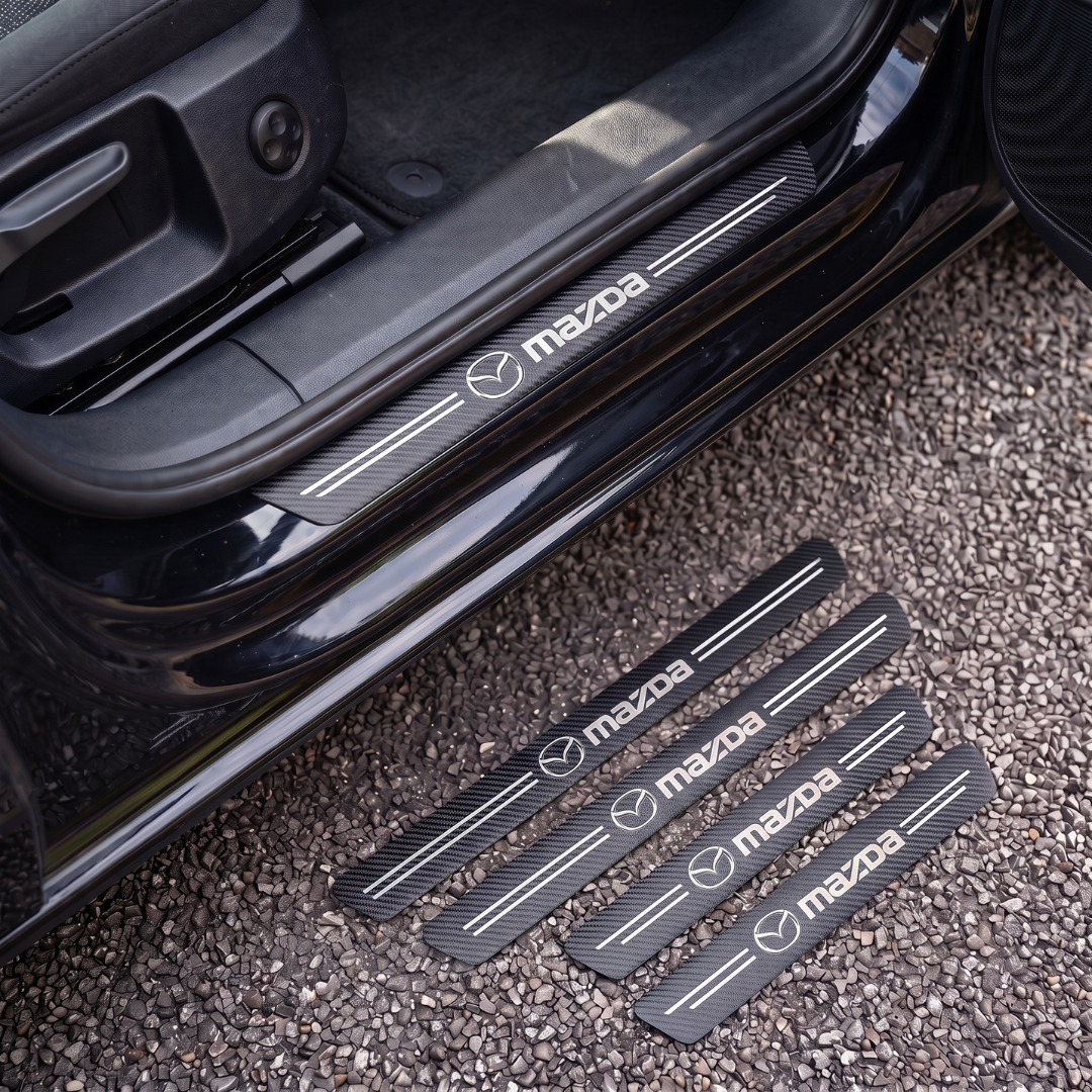 CarbonGrip PRO door sill protectors with Mazda logo: one fitted on the sill, set of 4 on the ground