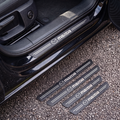CarbonGrip PRO door sill protectors with Mazda logo: one fitted on the sill, set of 4 on the ground